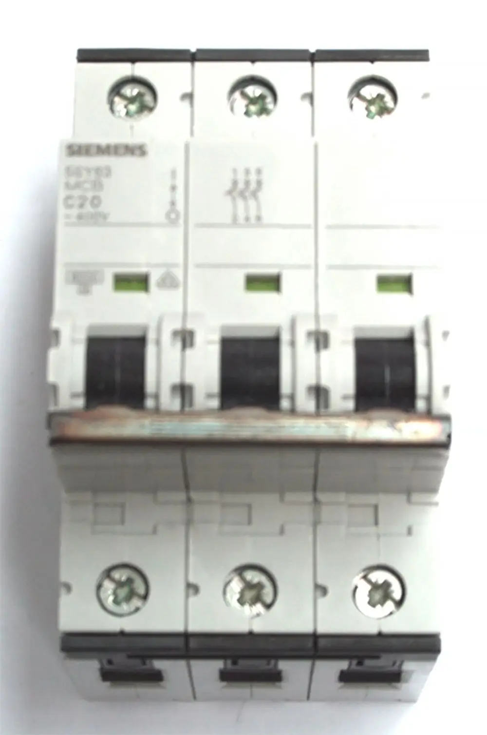 Daikin Sicherungsautomat mit drei Phasen, grünen Statusanzeigen und Schraubanschlüssen für elektrische Verbindungen, montiert auf einer weißen Trägerschiene.